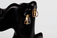 حلق ذهب دائري عيار 18 بتصميم مموج متداخل بوزن 3.7...