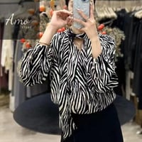 بلوزة لون أسود مع ابيض مشجر ب درابي مخصر و ياقة لف...