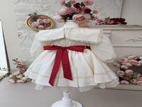 فستان كريمي بفيونكات حمراء