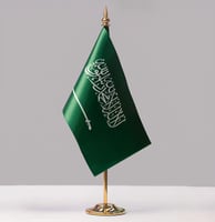 علم السعودية صغير مع سارية يوضع على الطاولة