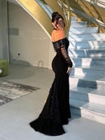 فستان أسود راقٍ بتصميم مكشوف الأكتاف