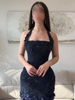 فستان سهرة كحلي مطرّز مع ذيل مزدان بالورود