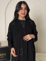 عباية سوداء نص كلوش مطرزة بنقوش نباتية ناعمة.