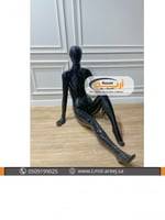 مانيكان اسود نسائي جالس على الارض