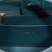 حقيبة نسائية مزينة بمعدن ذهبي اللون بشعار ماركة