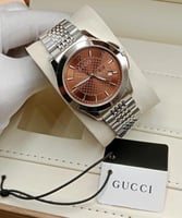 ساعه قوتشي لون بني اطار فضي