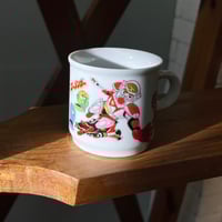 ‎كوب فنتج من السيراميك يحمل تصميمًا لشخصيات من مسل...