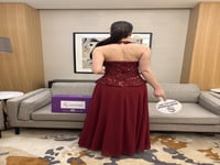 فستان سهرة عنابي بتطريز كريستالي وخصر محدد.