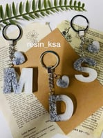 ميدالية مفاتيح على شكل حرف لون ابيض مطرز بورق الفض...