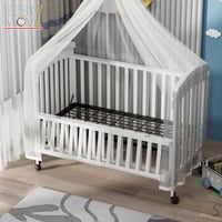 سرير أطفال خشبي بجانب سرير الأم بتصميم أنيق ومريح