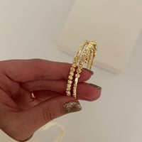 سوار مرن مؤلف من كرات ذهبية بينها فواصل مطلي ذهب ع...