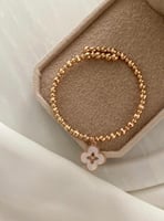 سوار مطلي ذهب مع كرات ذهبية ووردة فان كليف بيضاء M...