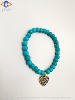سوار حجر الفيروز الطبيعي مع تعليقة القلب الذهبية .