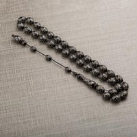 سبحة مطرزة بالفضي من اللون الأسود اللامع