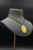 سبيكة ذهب وزن نصف اونصة عيار 24 شكل بيضاوي مع عروه