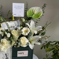 تنسيق زهور أبيض مع مبلغ مالي للتهنئة بالترقية