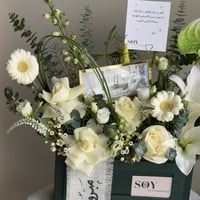 تنسيق زهور أبيض مع مبلغ مالي للتهنئة بالترقية