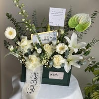 تنسيق زهور أبيض مع مبلغ مالي للتهنئة بالترقية