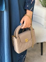 شنطة نسائية بشعار ذهبي