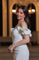 فستان أنيق وفخم، يتميز بتصميم طويل بلون أبيض ناصع...