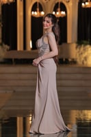 فستان بتصميم سهرة راقٍ بلون بيج ناعم، يتميز بقصة ع...