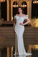 فستان أنيق وفخم، يتميز بتصميم طويل بلون أبيض ناصع...