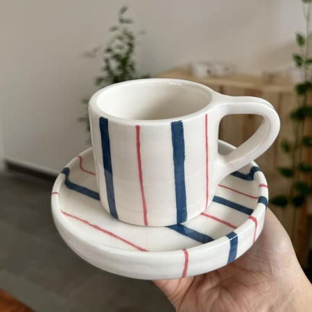 كوب مع طبق مخطط كحلي