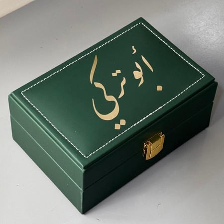 صندوق جلد مقسم يحتوي على (نص اوقية عود موروكي محسن + ربع تولة مسك)