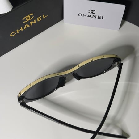 نظارة شانيل باللون الاسود وشعار باللون البيج على الإطار