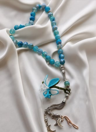 سبحة 33 عقيق برازيلي أزرق سماوي مزينة بوردة أويا كروشيه