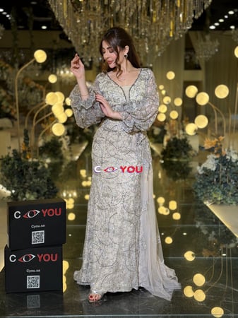 فستان سهرة شامبين مطرّز برقبة V وأكمام شفافة منفوشة مع درابيه جانبي.