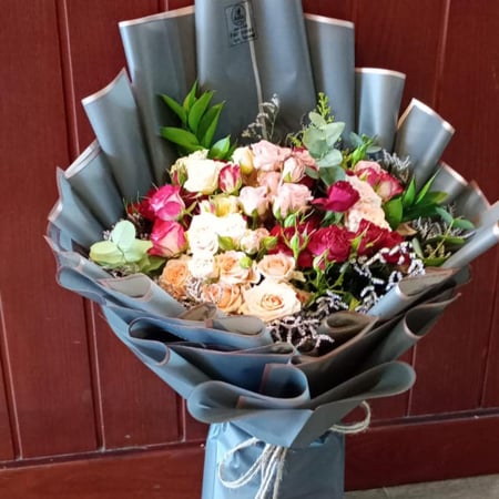 بوكيه ورد بيبي روز أحمر وزهري وبرتقالي درجة فاتحة مزين بأوراق خضراء