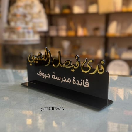 استاند اسم فاخر باللون الأسود مع خط ذهبي أنيق