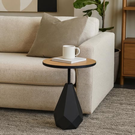 طاولة جانبية دائرية عصرية بسطح خشبي وقاعدة هندسية سوداء.