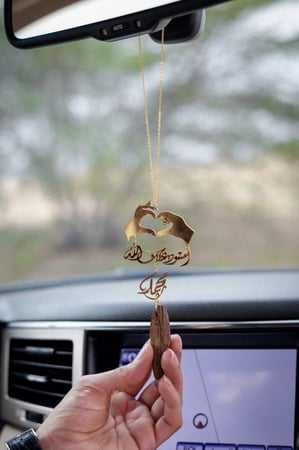 تعليقة السيارة بشكل يدين قلب