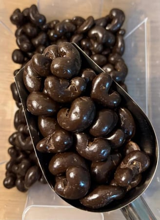 كاجو مغطى بالشوكولاتة الداكنة الفاخرة في مغرفة