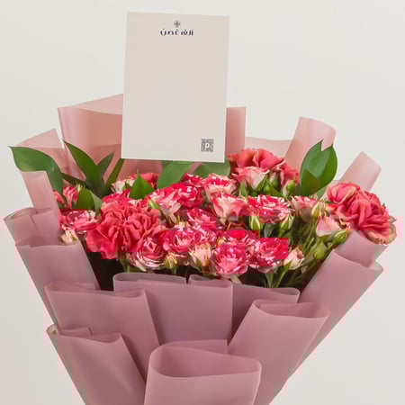 تنسيق زهور وردية مع تغليف مميز للباقة