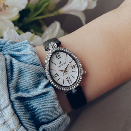 ساعة نسائية بتصميم مميز جلد بلون اسود اطار فضي ميناء ابيض