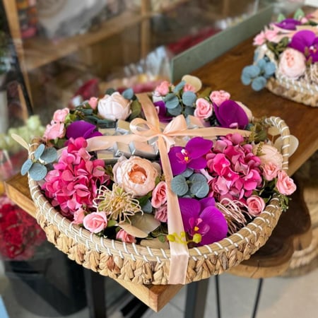 سلة ورد صناعي أنيقة مزينة بزهور ملونة مع شوكولاتة فاخرة للتقديم