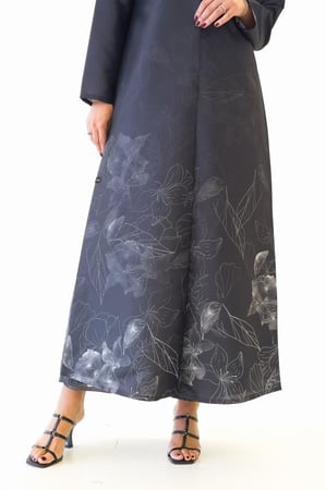 عباية سوداء تفته مع فستان بطبعات ورود