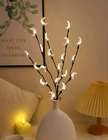 إضاءة فنية على شكل فروع شجر مصممة على شكل هلال