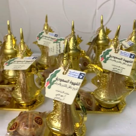 مجموعة (12) توزيعات دلة قهوة مع صحن بكتل ذهبي مع كتابة العبارة المطلوبة بلاستيك