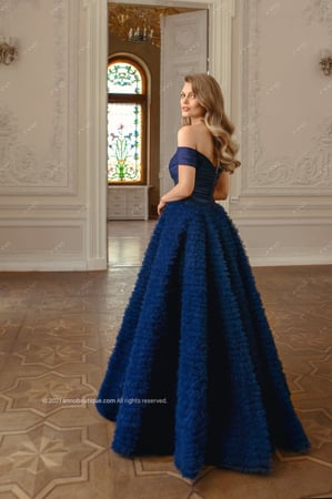 ‏  Off-shoulder gown with ruffle skirt