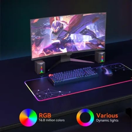 سماعات ستيريو مكتبية للألعاب ميشن مع إضاءة RGB رمادي موضوعة بجانب شاشة