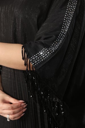 فستان سهرة ياقة مدورة وأكمام مزينة بالترتر بنهايات مزينة بشباشيل لامعة وتنورة بكسرات