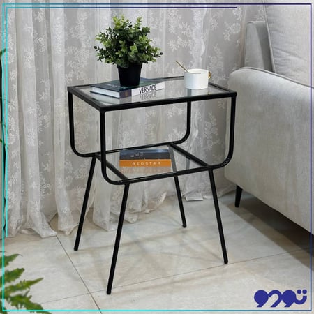 طاولة جانبية كمدينه بلون اسود و بسطح زجاجي شفاف