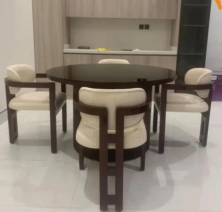 طاولة طعام مودرن بتصميم دائري فاخر وأربعة كراسٍ ذات طابع هندسي معاصر
