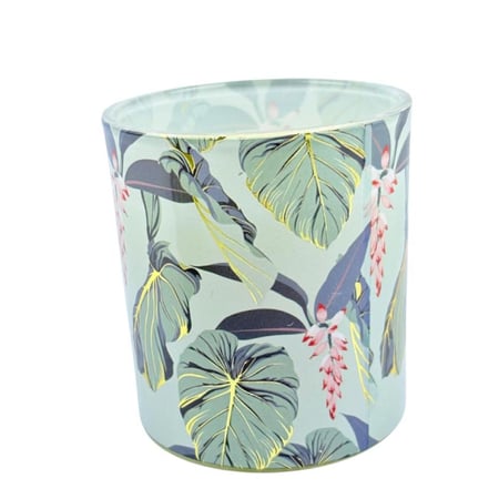 شمعة  معطرة بزخارف نباتية وغطاء ذهبي