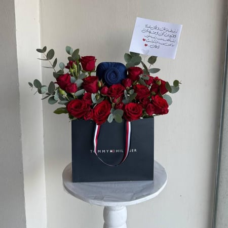 باقة ورد حمراء مع اسورة تومي هيلفيغر بجدة