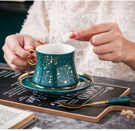 فنجان قهوة فاخر من السيراميك مع طبق تقديم وملعقة